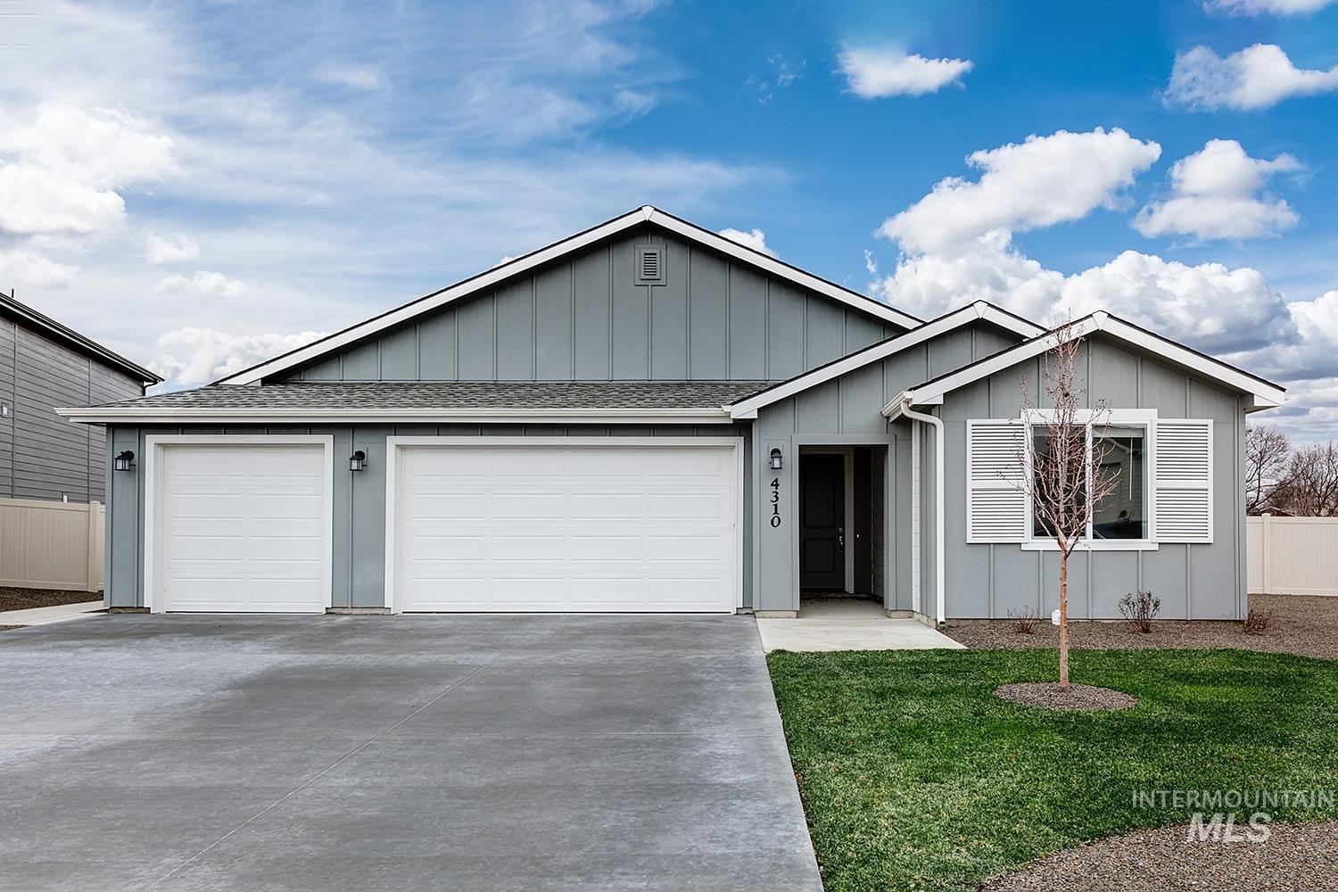 Ranch-style house featuring roof with shingles, an attached garage, driveway, and board and batten siding