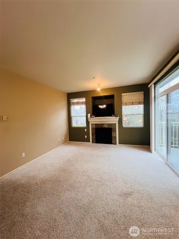 a view of empty room with a fireplace and windows