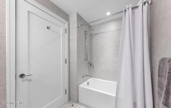 a bathroom with a tub a sink and a shower