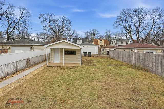 a view of a house with a large tree and a yard