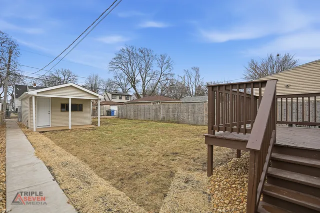 a view of a house with backyard and wooden fence