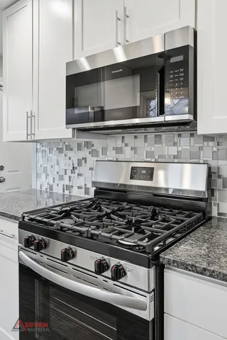 a stove top oven sitting inside of a kitchen