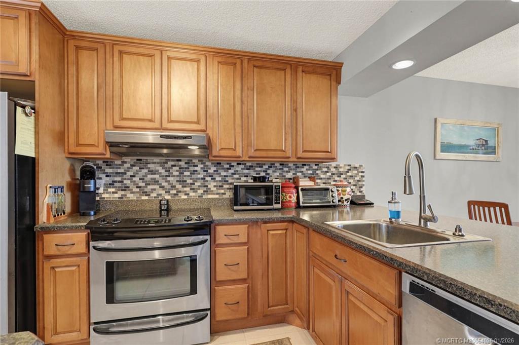 1950 Southwest Palm City Road, Unit 8106 Stuart, FL 34994 - Photo 9 of 54 a kitchen with granite countertop a sink stainless steel appliances and cabinets