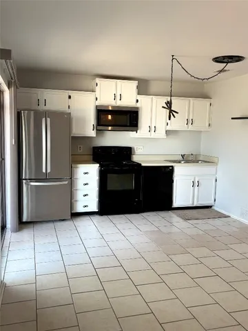 a large kitchen with cabinets and stainless steel appliances