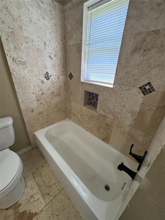 803 Ripley Avenue Ennis, TX 75119 - Photo 29 of 40 Bathroom featuring a tiled tub surround with decorative accents and a recessed niche