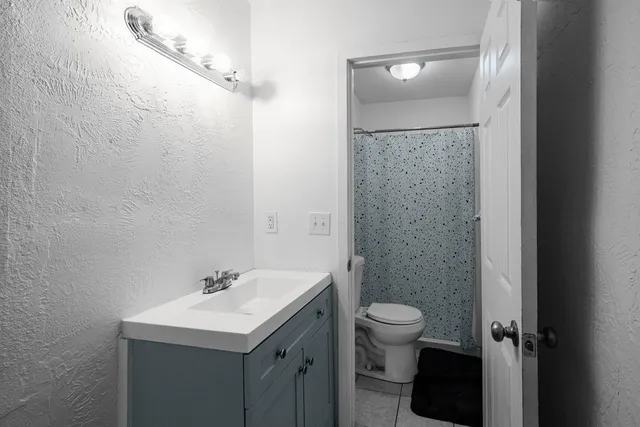 a bathroom with a sink toilet and a mirror