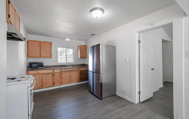a kitchen with stainless steel appliances granite countertop a refrigerator and a stove top oven