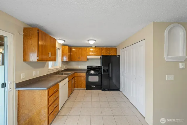 a kitchen with a stove a refrigerator and a sink