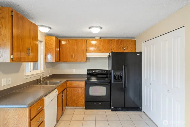 a kitchen with stainless steel appliances granite countertop a sink stove and cabinets