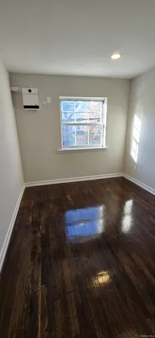 an empty room with wooden floor view and windows