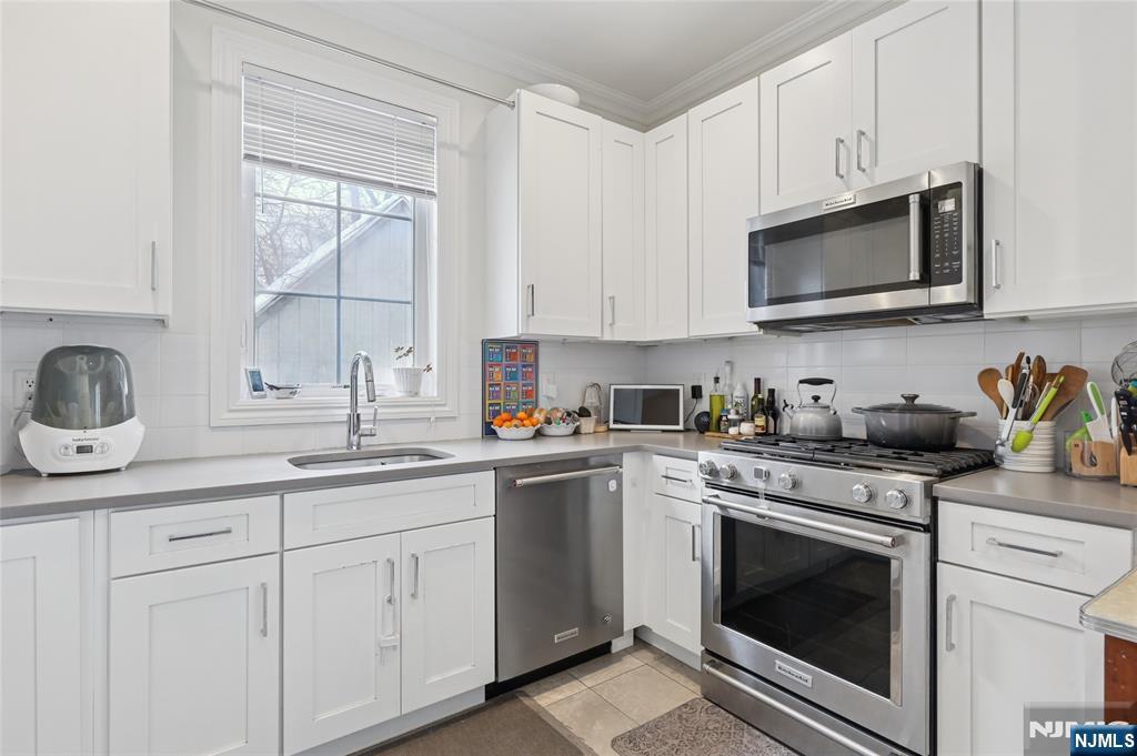 45-47 Franklin Street Tenafly, NJ 07670 - Photo 12 of 41 a kitchen with cabinets stainless steel appliances a sink and a window