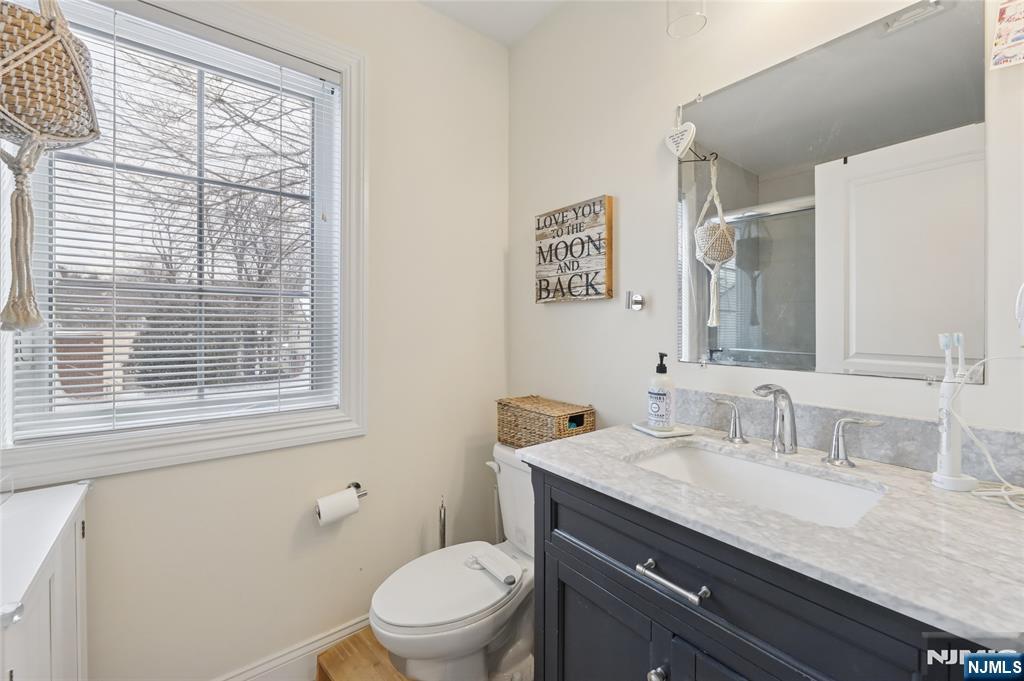 45-47 Franklin Street Tenafly, NJ 07670 - Photo 27 of 41 a bathroom with a granite countertop sink toilet a large mirror and a window