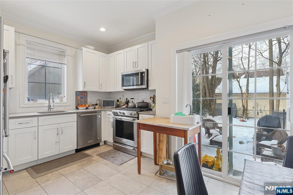 45-47 Franklin Street Tenafly, NJ 07670 - Photo 9 of 41 a kitchen with stainless steel appliances granite countertop a stove top oven a sink a dining table and chairs