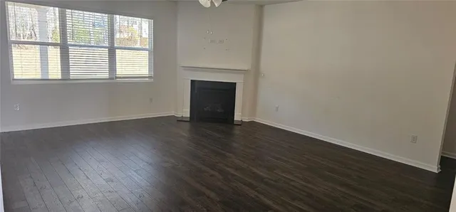 an empty room with wooden floor and a window