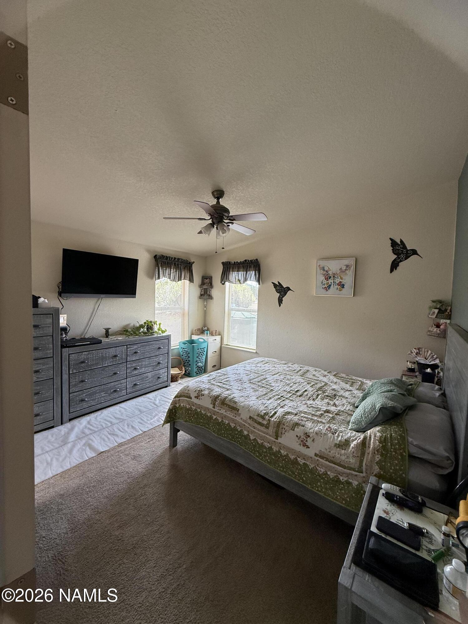 1431 East Cedar Road Williams, AZ 86046 - Photo 29 of 51 a bedroom with a bed and a flat tv screen on a dresser