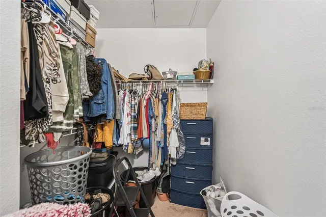 a view of walk in closet with clothes