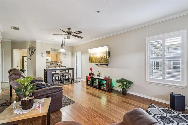 a living room with furniture a flat screen tv and a large window