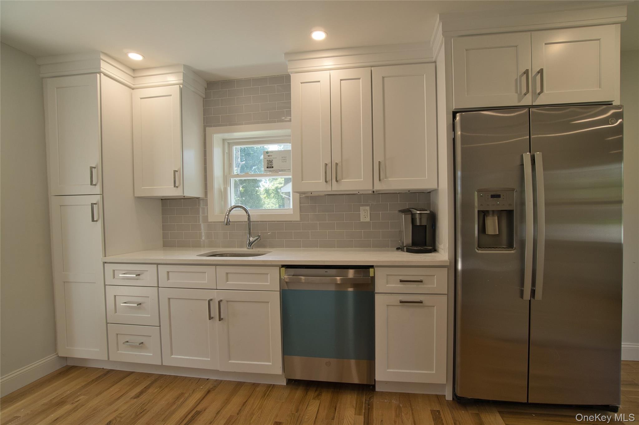 29 Overlin Road Patterson, NY 12563 - Photo 6 of 16 Modern kitchen featuring white shaker cabinetry, stainless steel appliances, a white solid surface countertop, and a light gray subway tile backsplash