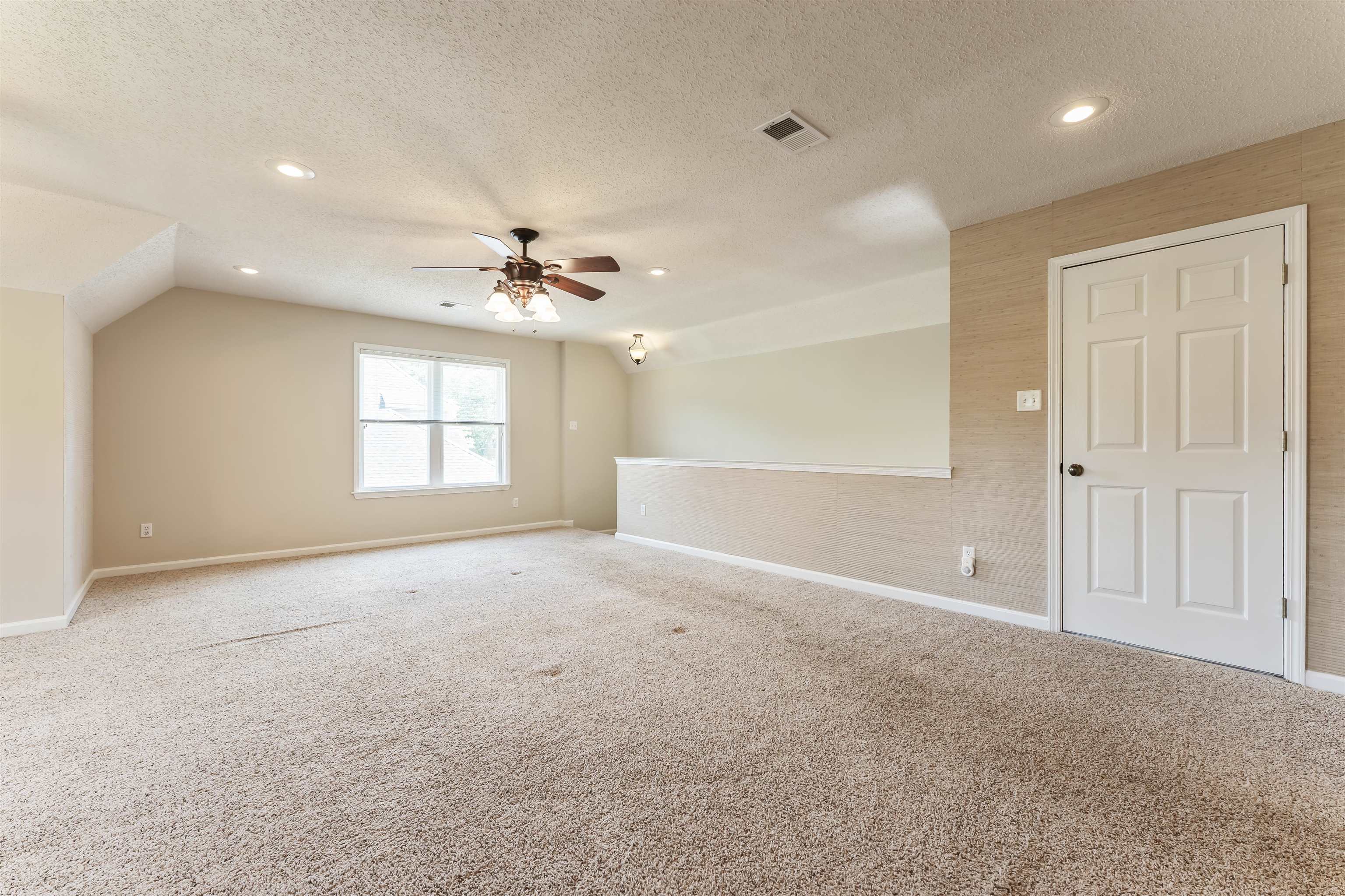 4279 High Plains Road Bartlett, TN 38135 - Photo 27 of 37 Expansive carpeted room featuring a ceiling fan with integrated lighting, recessed lighting, a multi-pane window, and a paneled door