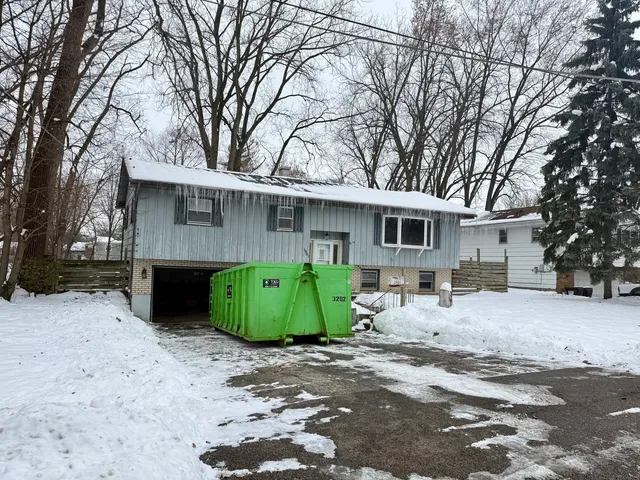 a view of a house with a yard covered with snow in the road