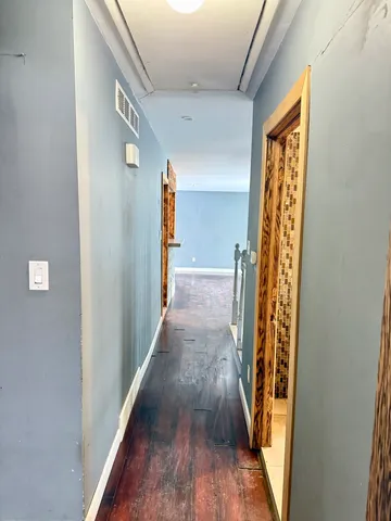 a view of a hallway with wooden floor and staircase