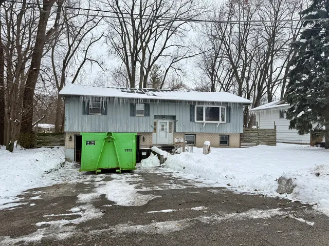 a front view of a house with a yard and trees