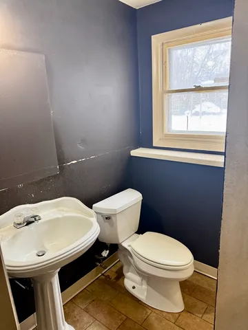 a white toilet sitting next to a bathroom sink