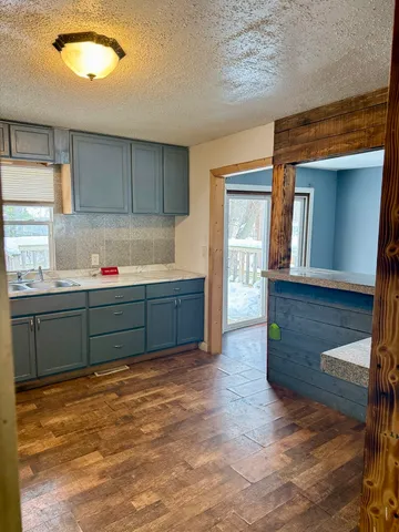 a kitchen with granite countertop a sink and a wooden cabinets