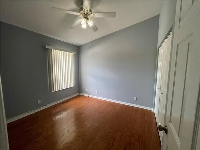 an empty room with windows and fan