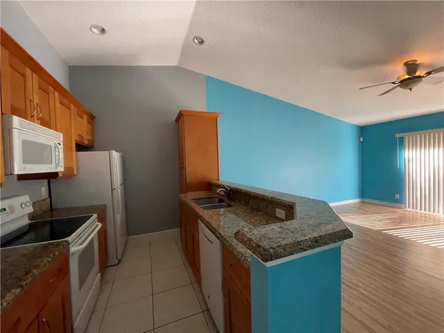 a kitchen with stainless steel appliances granite countertop a sink and a refrigerator