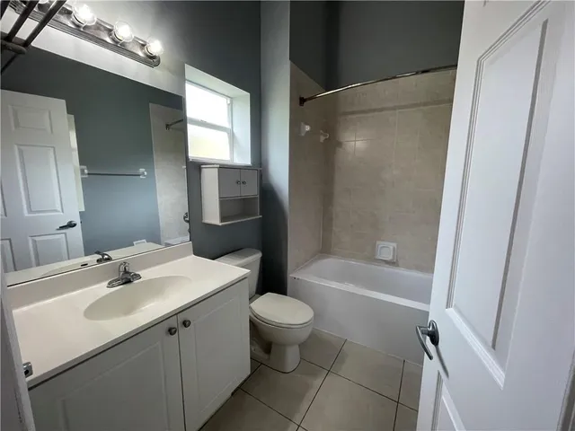 a bathroom with a sink a toilet a mirror and shower