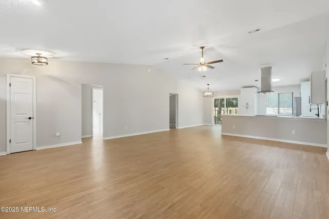 a view of an empty room with a kitchen