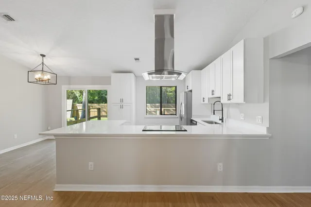 a room with kitchen island granite countertop a sink and a window