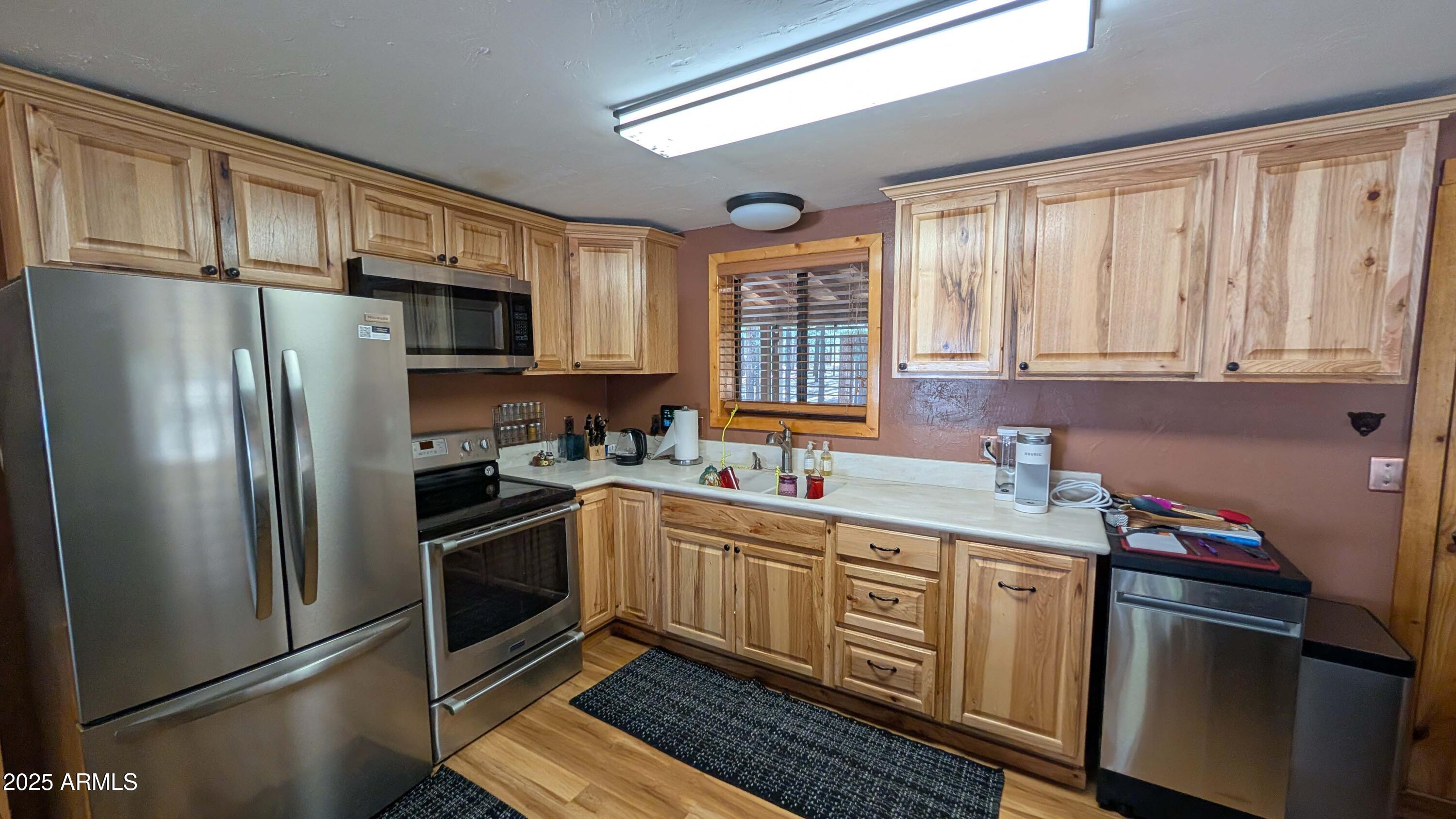 2425 Tall Trees Loop Forest Lakes, AZ 85931 - Photo 11 of 43 a kitchen with stainless steel appliances a sink cabinets and a window
