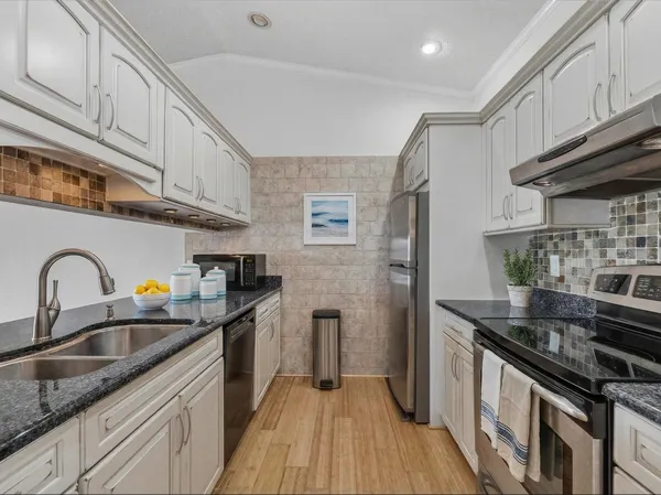a kitchen with stainless steel appliances granite countertop a sink stove and refrigerator