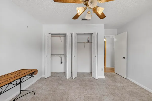 a view of room with a chandelier fan and closet