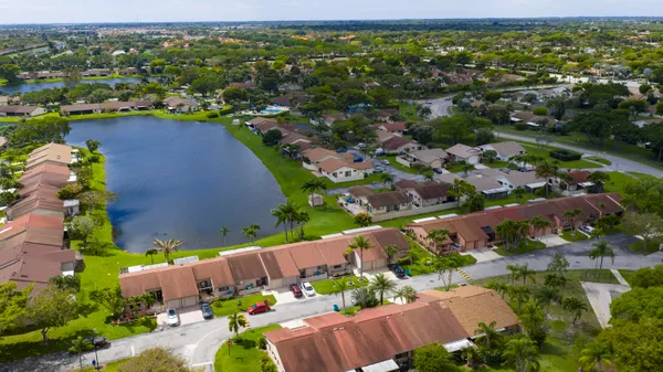 an aerial view of a house with a yard and lake view
