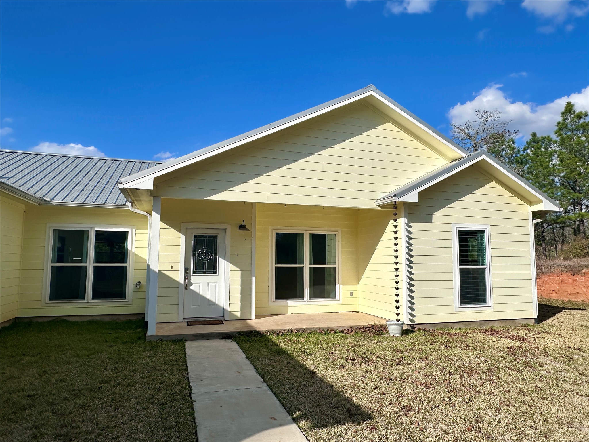 124 Pine Path Bastrop, TX 78602 - Photo 3 of 31 Covered front porch, metal roof and a yard