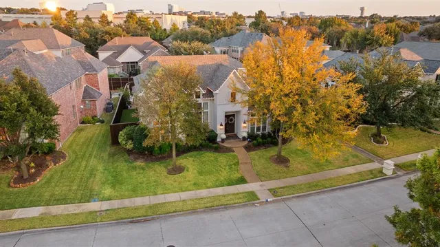 an aerial view of residential houses with outdoor space and trees