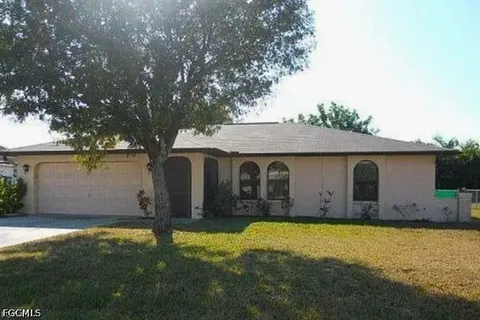 a view of a house with yard and a tree