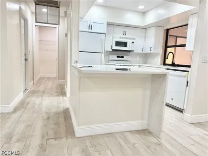 a kitchen with stainless steel appliances cabinets a sink and a refrigerator