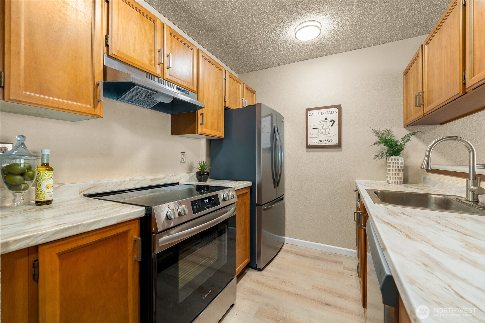 1175 Harrington Place Northeast, Unit 205 Renton, WA 98056 - Photo 5 of 30 a kitchen with stainless steel appliances granite countertop a stove a sink and a refrigerator