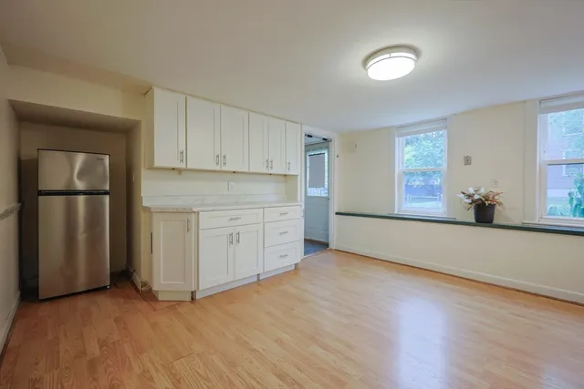 a view of a kitchen with wooden floor and electronic appliances