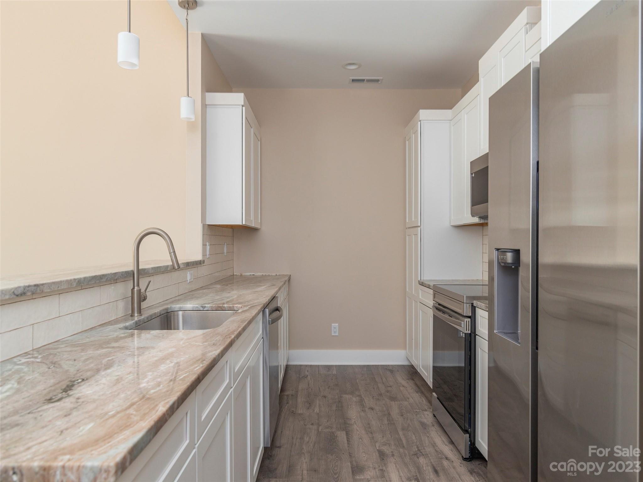25 Heartleaf Circle Arden, NC 28704 - Photo 10 of 16 a kitchen with stainless steel appliances granite countertop a sink and a refrigerator