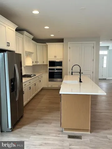 a kitchen with a refrigerator sink and cabinets