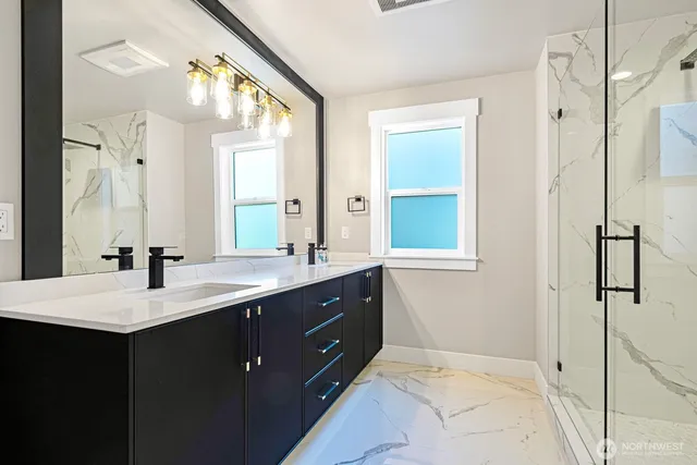 a en suite bathroom with a sink mirror and a shower