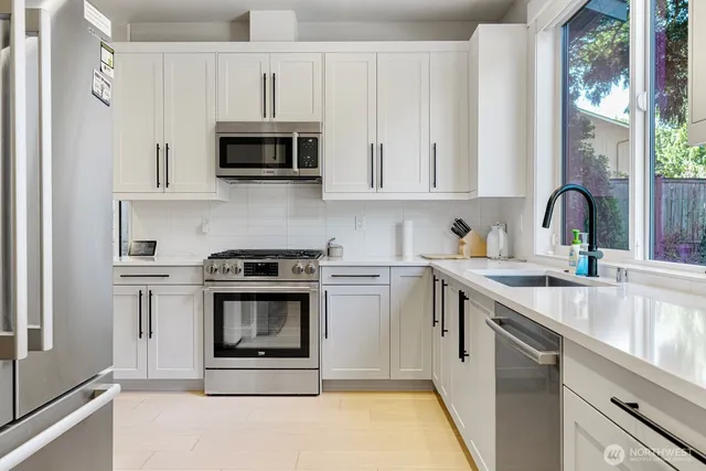 a kitchen with stainless steel appliances a stove a sink and a microwave