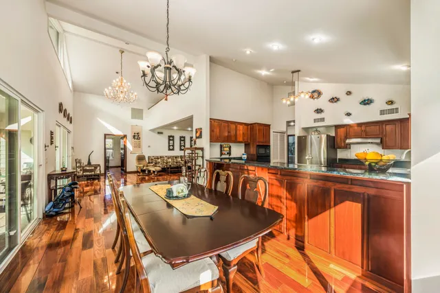 a view of a dining room and livingroom with furniture wooden floor a chandelier