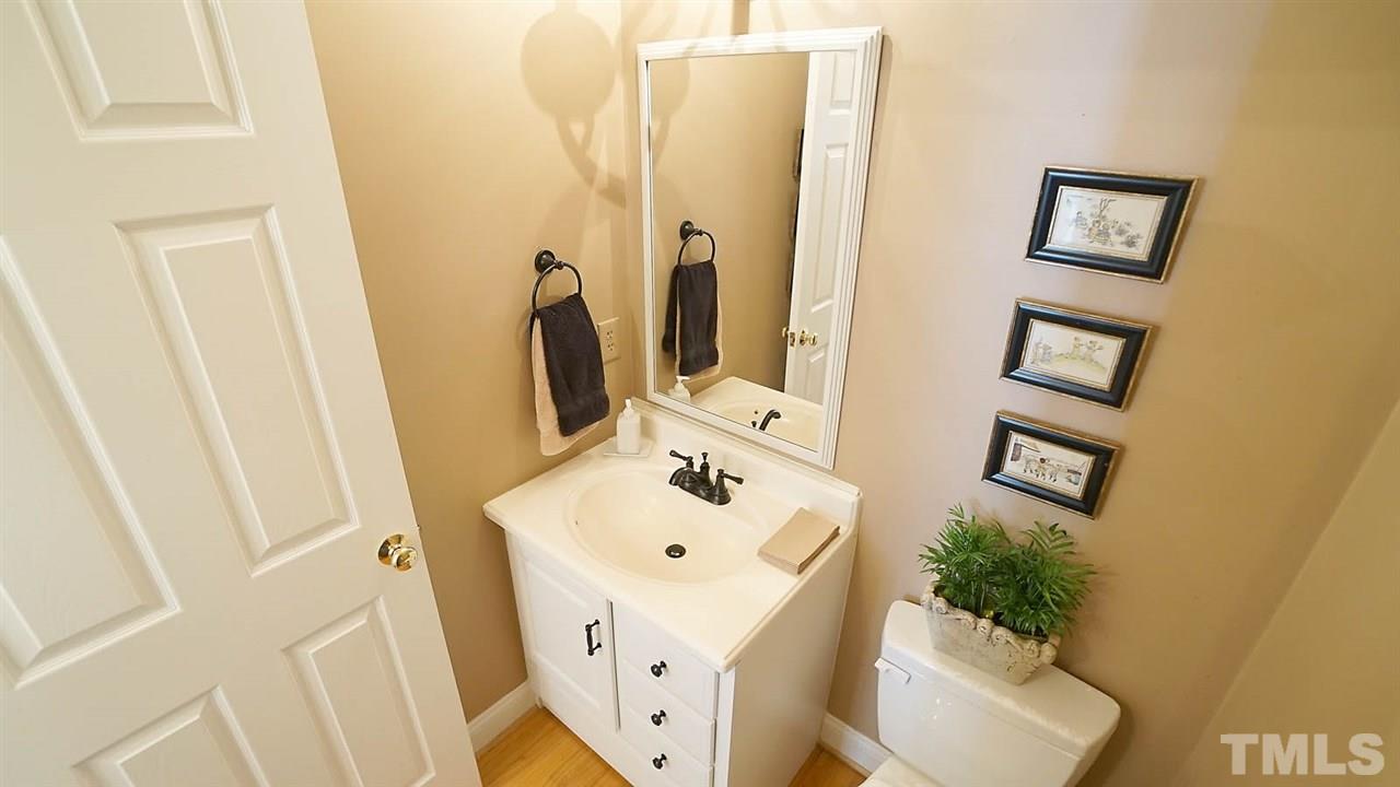 9124 Carrington Ridge Drive Raleigh, NC 27615 - Photo 5 of 24 a bathroom with a sink and mirror with window