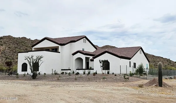 a view of a white house with a yard and wooden fence
